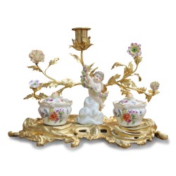 Un encrier \"Putto tenant une guirlande de fleurs\" de style Louis XV en porcelaine.